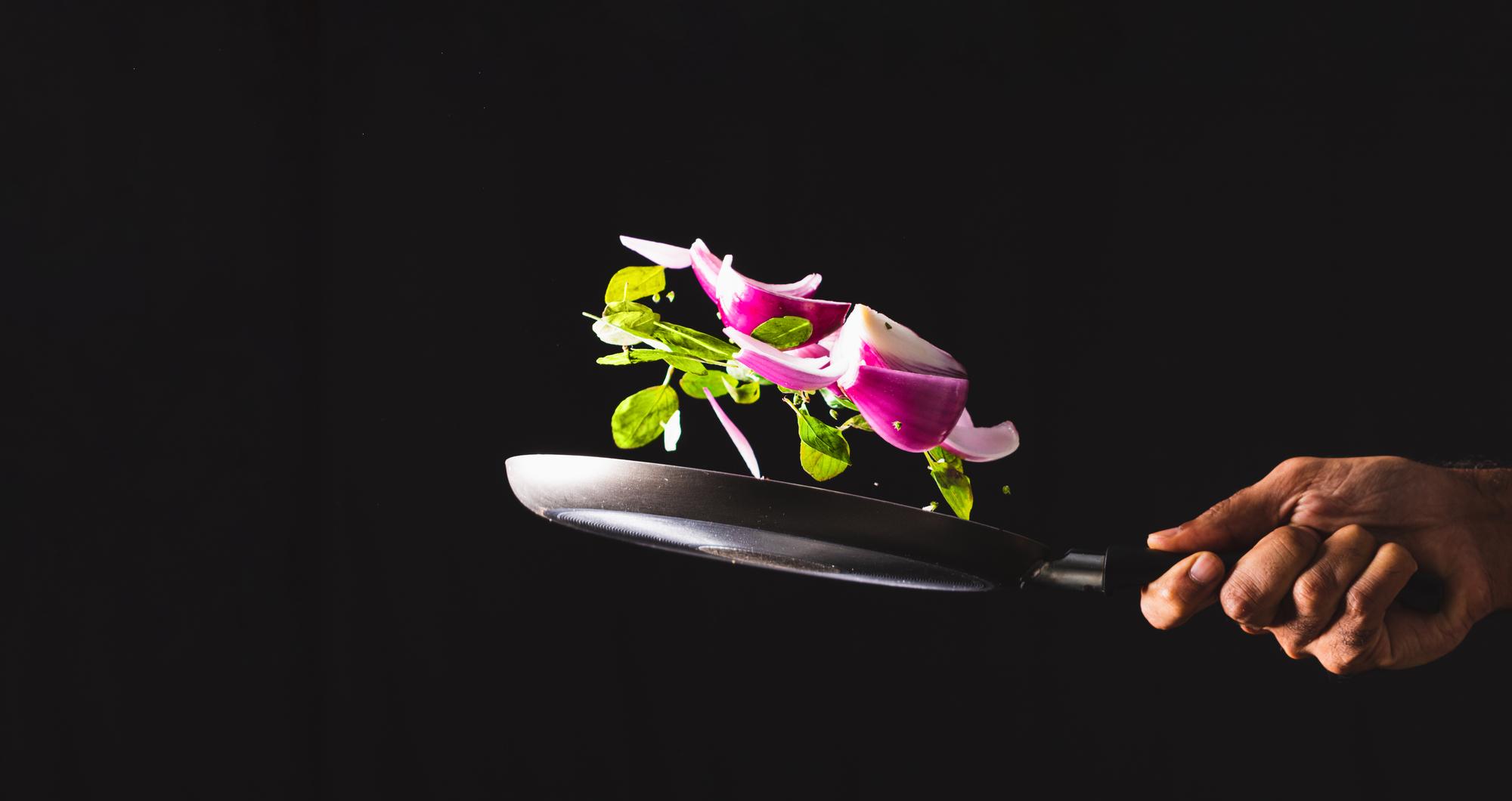 chef plating tech-driven dish with neon garnish